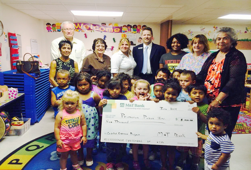 At the M&T Bank check presentation to Primeros Pasos are (l-r) David Baker, board building chair; Laura Eton, teacher; Sally Beaumont, board president; M&T staff teller Marilyn Veguilla, and branch manager Steve Loughren Jr.; Damara Wise, teacher; Liz Shifflet, teacher; and Maria Joseph, center director; and Primeros Pasos students. SOURCE SUBMITTED